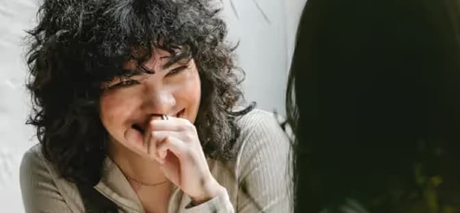 Smiling woman with curly hair engaged in conversation
